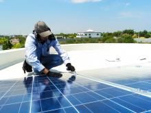 Worker installing solar panel roof