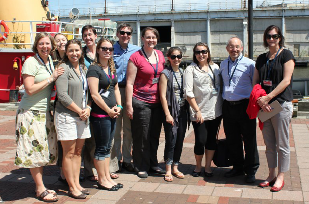 A group of people pose for their photo to be taken on a pier