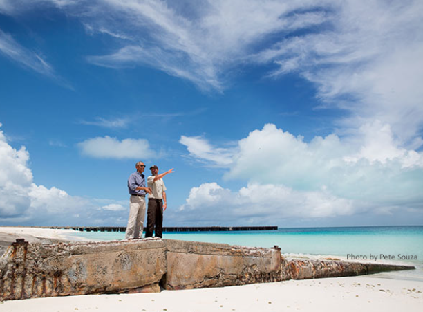 Two men stand on a sea wall