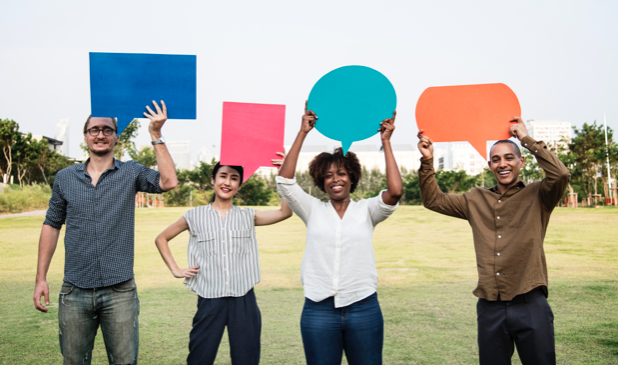 People holding colorful shapes in a field