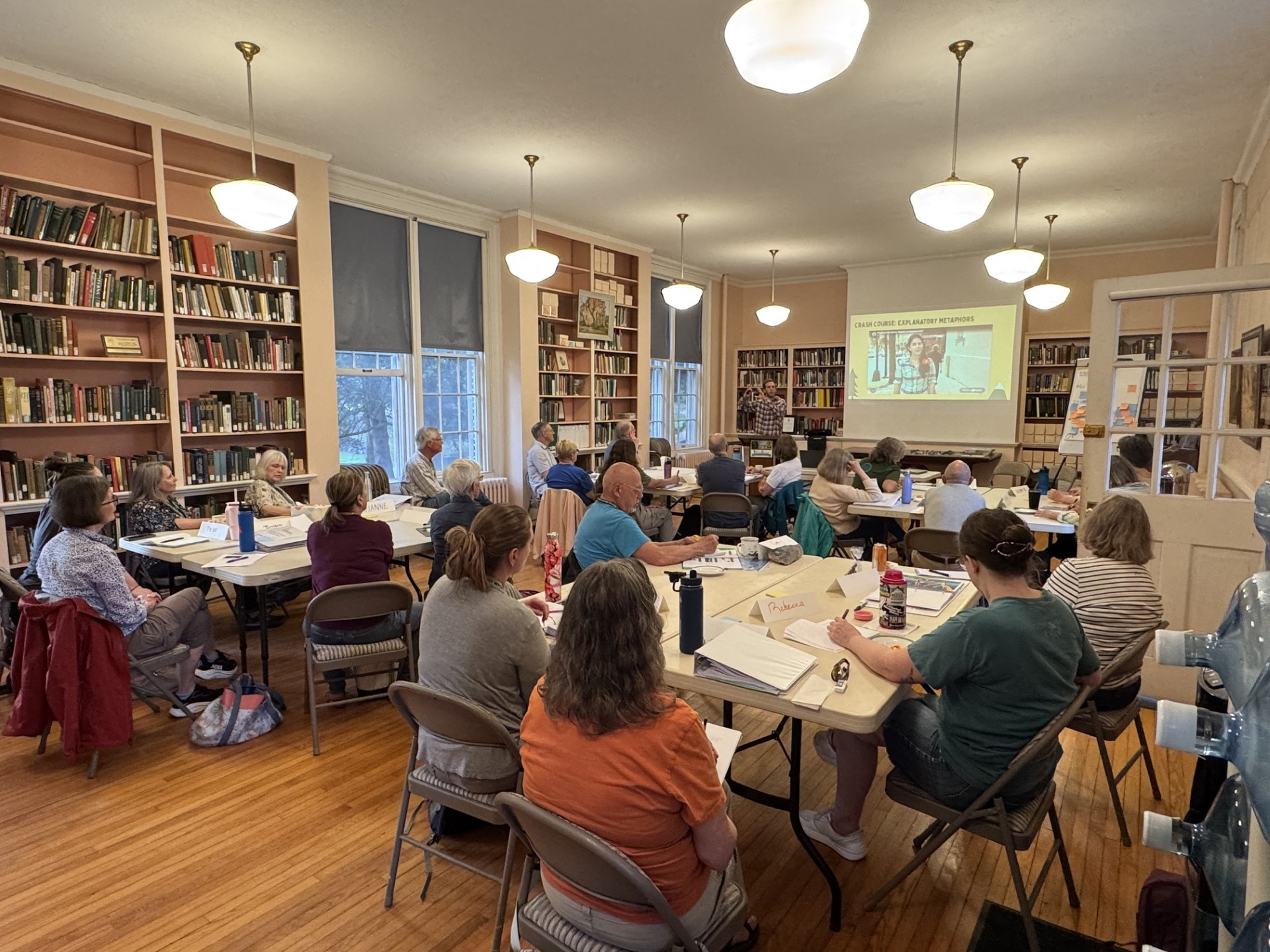 A room of people listen to a presentation on climate communication.